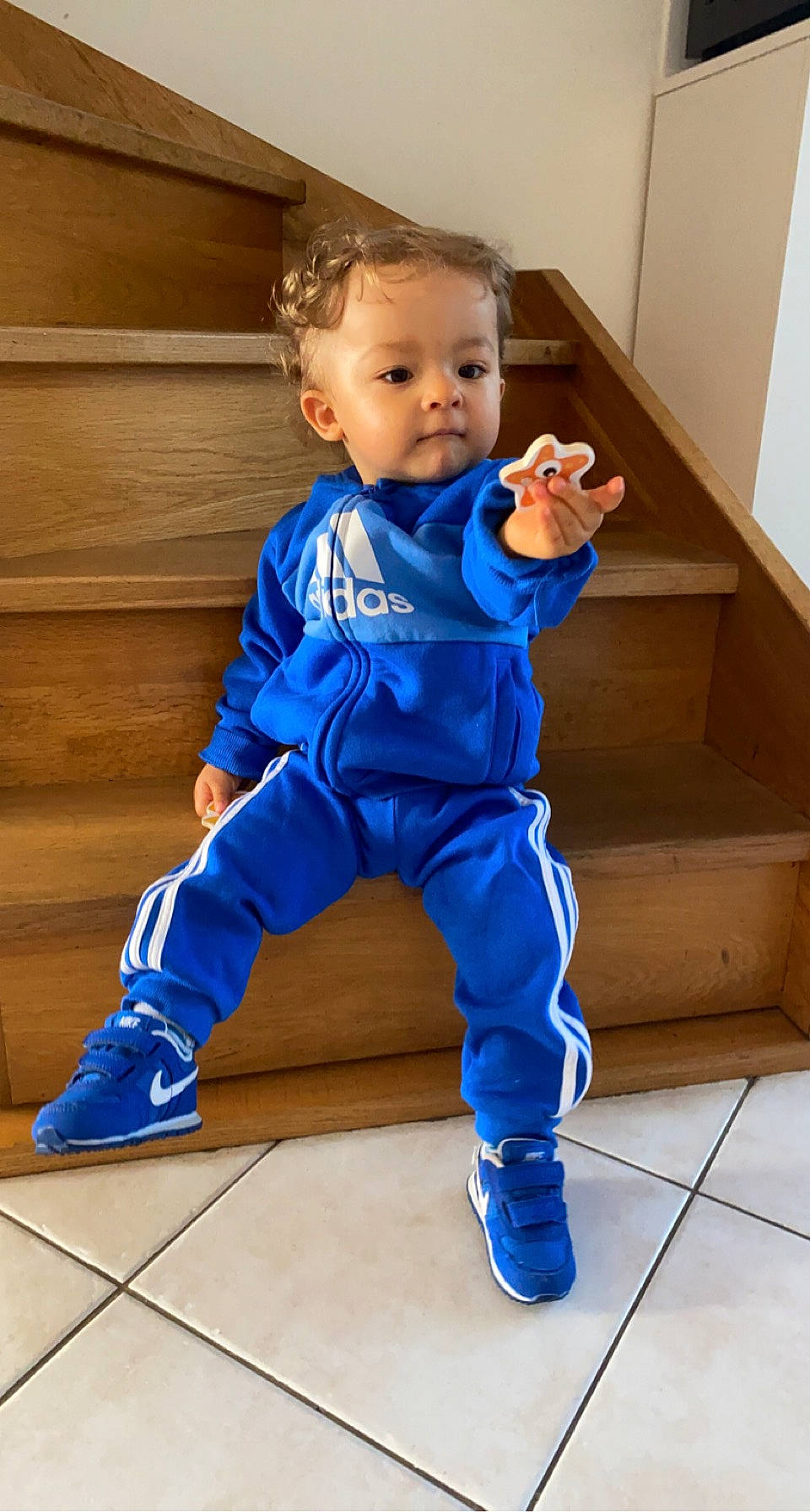 Nino participe au concours pour gagner de l'argent avec cette photo : active_pants, baby, baby_toddler_clothing, barefoot, electric_blue, eye, face, floor, flooring, hair, hardwood, head, human_body, person, sleeve, smile, sportswear, sweatpant, thigh, toddler