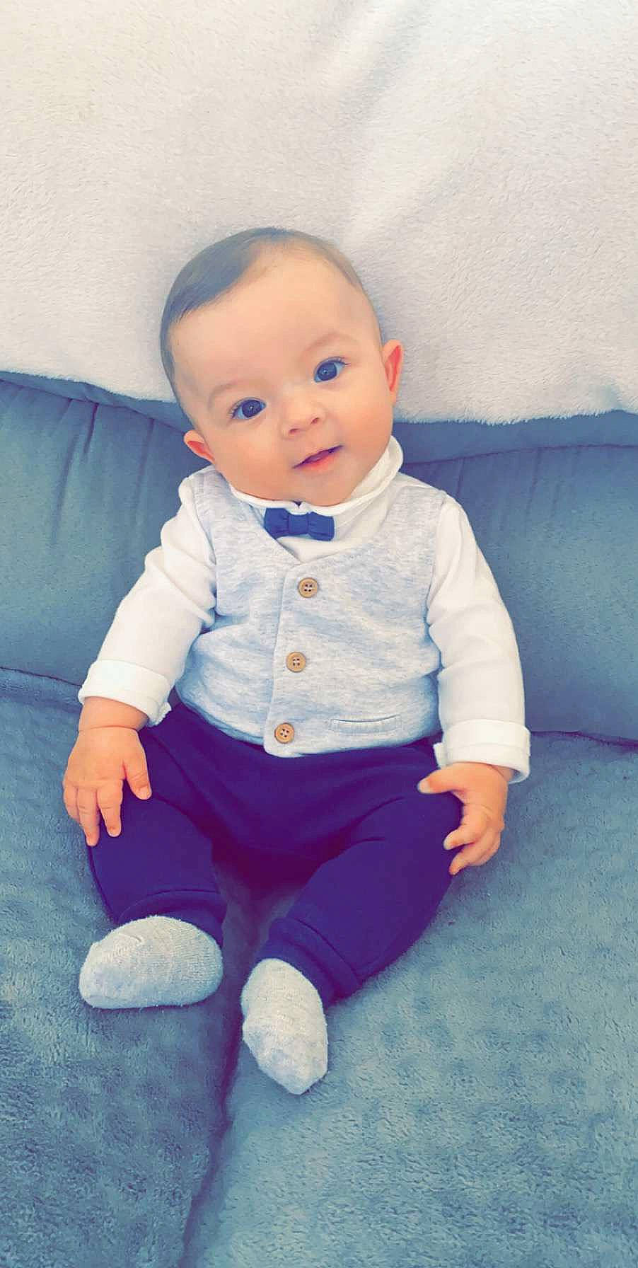 Nino participe au concours pour gagner de l'argent avec cette photo : baby, baby_products, baby_toddler_clothing, blue, cheek, child, head, person, sitting, skin, sleeve, standing, toddler