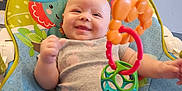 Karsyn is registered to the contest to win money with this photo: arm, baby, baby_seat, child, closeup, clothing, colorful, cute, face, happy, head, indoor, infant, leg, person, plastic_toy, playful, seat_belt, smiling, toy
