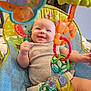 baby, smiling, baby_seat, toy, colorful, infant, playful, happy, child, indoor, person, cute, seat_belt, clothing, face, head, arm, leg, plastic_toy, closeup