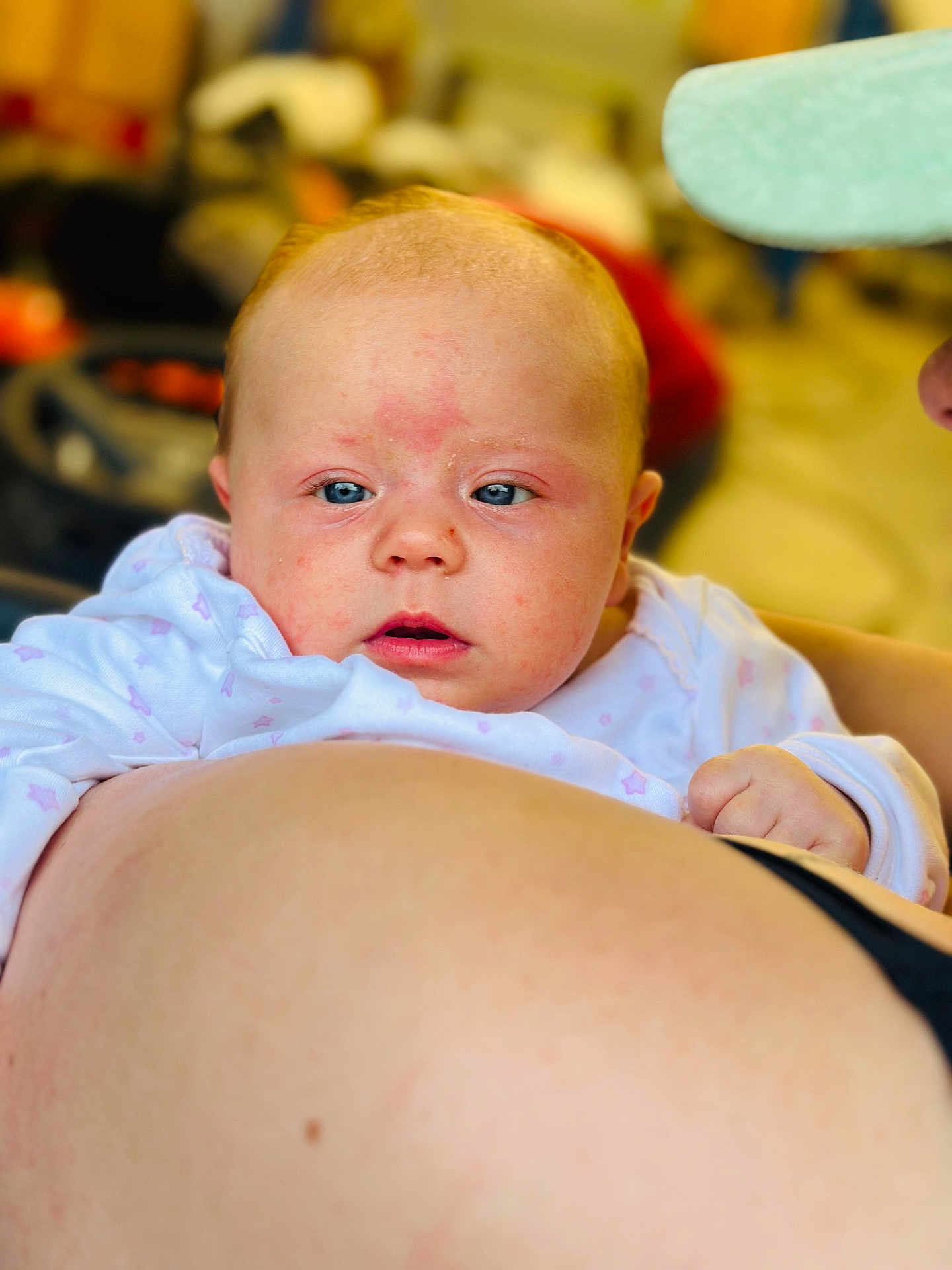 Karsyn is registered to the contest to win money with this photo: baby, infant, face, blue_eyes, skin, person, clothing, hand, adult, holding, closeup, expression, curious, indoor, blurred_background, light, soft_focus, head, newborn, portrait