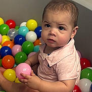 Xavier is registered to the contest to win money with this photo: baby, ball_pit, child, colorful_balls, curious, cute, expression, face, hands, indoor, pink_shirt, play, portrait, recreation, short_hair, sitting, skin, toddler, toy, young_child