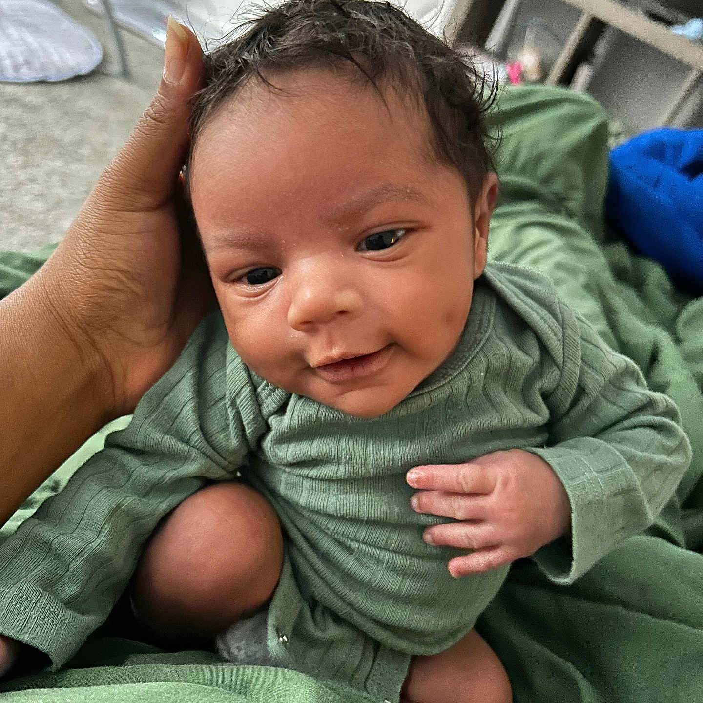 Tyus is registered to the contest to win money with this photo: baby, child, closeup, cozy, cute, face, family, green_clothing, hand, human, indoor, infant, newborn, person, portrait, resting, skin, smile, soft_fabric, warm