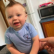 Isaac is registered to the contest to win money with this photo: baby, blue_shirt, cabinet, child, countertop, cute, face, hand, happy, indoor, kitchen, microwave, mohawk, person, playful, portrait, refrigerator, sitting, smiling, snacks