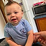 baby, blue_shirt, cabinet, child, countertop, cute, face, hand, happy, indoor, kitchen, microwave, mohawk, person, playful, portrait, refrigerator, sitting, smiling, snacks