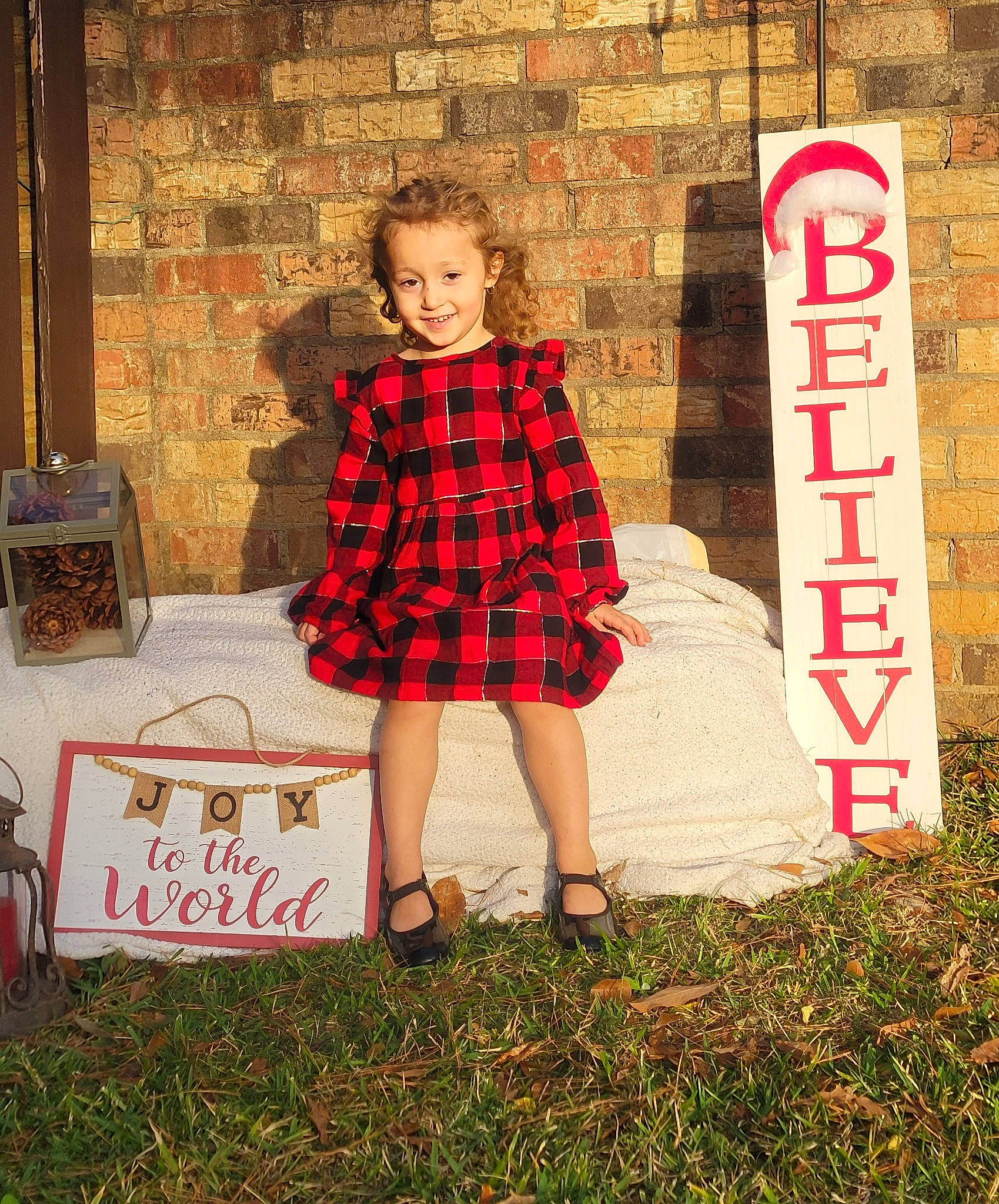 Kylin is registered to the contest to win money with this photo: clothing, day_dress, dress, fashion_design, flash_photography, flooring, formal_wear, grass, happy, human_leg, joy, one_piece_garment, pattern, person, plaid, plant, street_fashion, tartan, textile, toddler