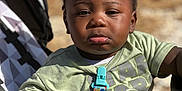 Khimerie is registered to the contest to win money with this photo: toddler, child, stroller, green_tshirt, star_wars, pacifier_clip, hand, face, outdoor, sunlight, serious_expression, black_hair, clothing, person, baby, seat, daylight, skin, holding, closeup
