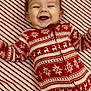 baby, child, smiling, happy, pajamas, red, white, reindeer, snowflake, holiday, christmas, striped, background, cute, infant, lying_down, festive, joyful, clothing, patterned