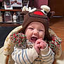 Thomas is registered to the contest to win money with this photo: baby, child, infant, smiling, happy, hat, knitted_hat, reindeer, pom_poms, clapping_hands, baby_walker, striped_clothing, indoor, face, person, wooden_floor, photograph_frames, jars, homedecor, cozy