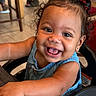 toddler, child, smiling, happy, curly_hair, blue_dress, high_chair, indoor, table, cute, person, portrait, baby, skin, face, hair_ties, expression, seat, arm, closeup