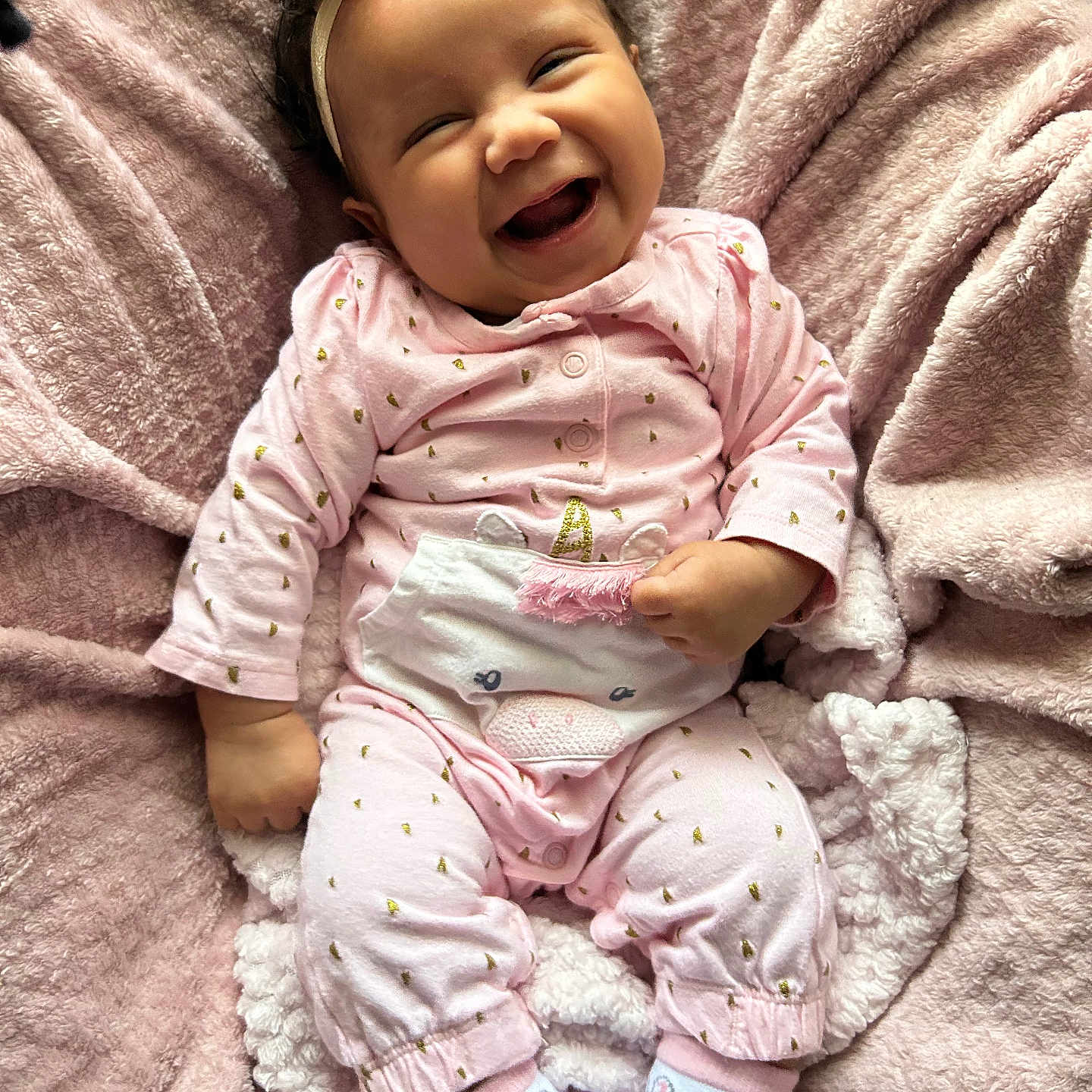 Nova is registered to the contest to win money with this photo: baby, babylaughing, bed, blanket, bodypart, clothing, face, furniture, happy, head, laughing, newborn, pajamas, pants, person, photography, portrait, quilt, sitting, smile