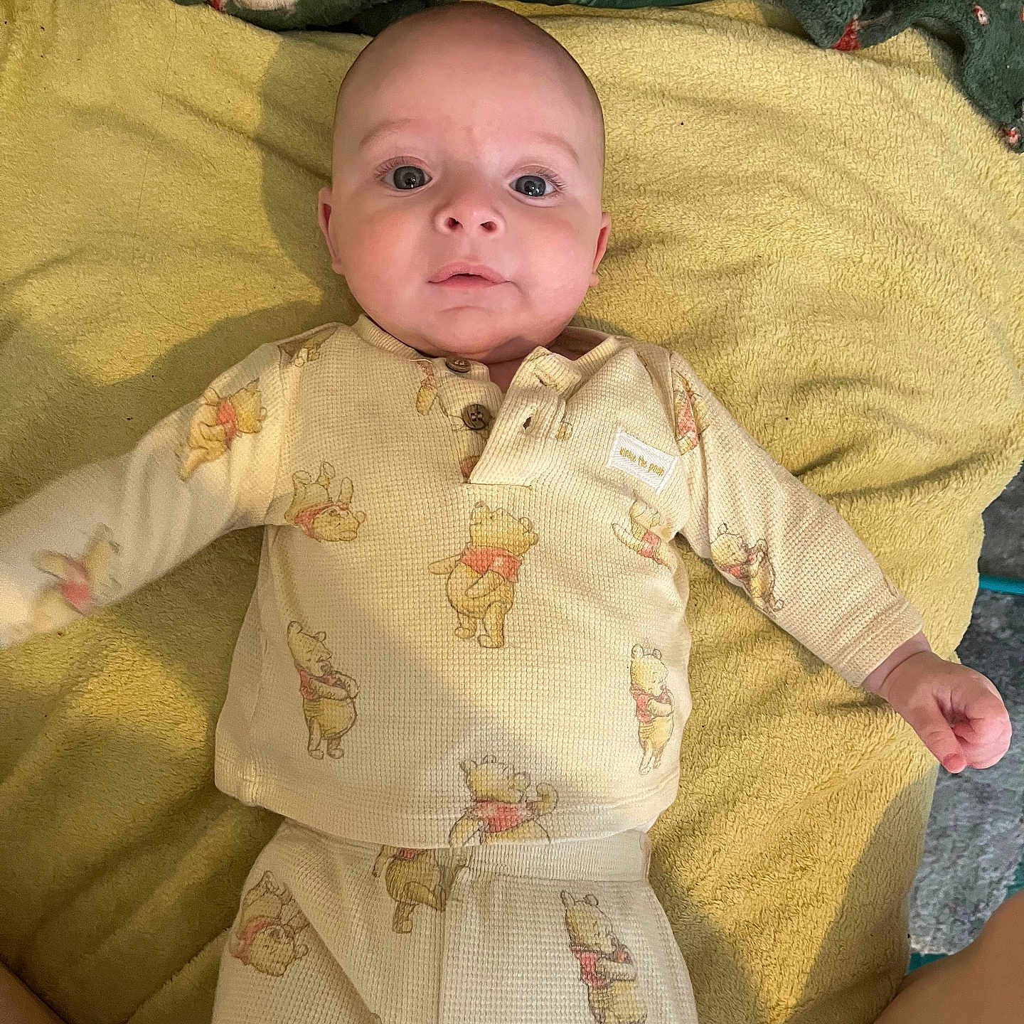 Noa joined the competition — help win amazing prizes! baby, blanket, child, clothing, comfort, cute, expression, face, green, indoors, infant, lying_down, pajamas, person, plush, portrait, sleepwear, soft, winnie_the_pooh, yellow