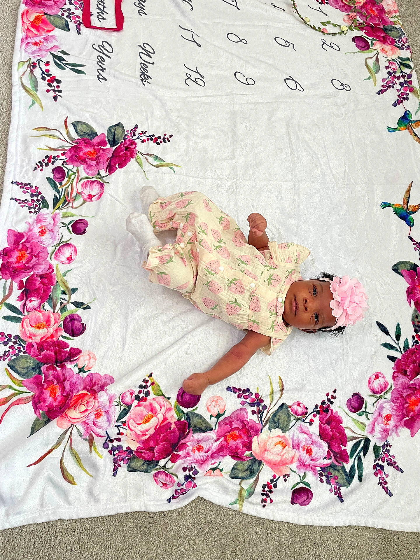 Kimber is registered to the contest to win money with this photo: adorable, baby, birds, blanket, carpet, child, colorful, cute, floral, flower_headband, indoor, infant, laying_down, numbers, patterned_clothing, pink, portrait, soft, strawberry_pattern, young_child