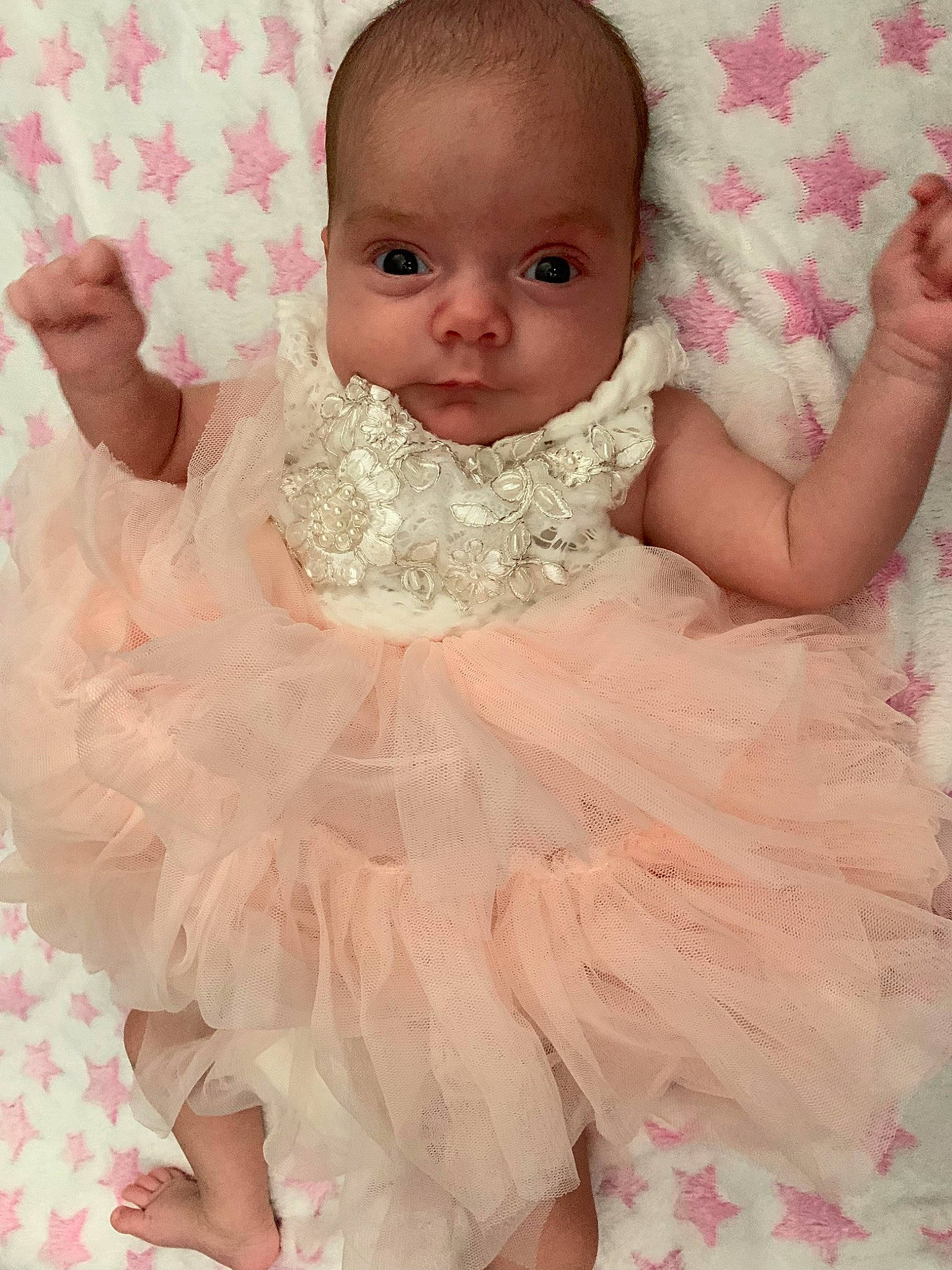 Mika is registered to the contest to win money with this photo: arm, baby, baby_toddler_clothing, bridal_accessory, cheek, dress, embellishment, face, finger, hand, happy, headpiece, iris, neck, person, pink, shoulder, skin, sleeve, toddler