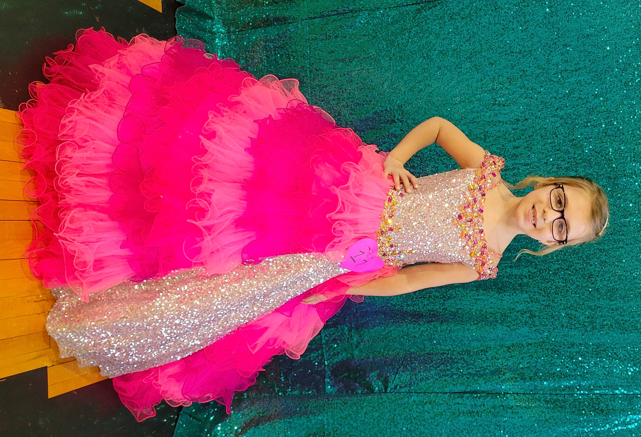 Sarah is registered to the contest to win money with this photo: baby_toddler_clothing, cocktail_dress, day_dress, embellishment, fashion_accessory, fashion_design, human_leg, joy, leg, magenta, one_piece_garment, pattern, peach, person, pink, ruffle, sleeve, textile, thigh, trunk