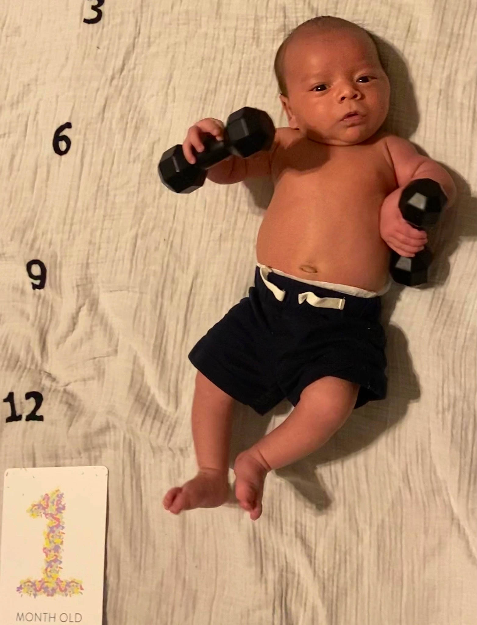 Jameson is registered to the contest to win money with this photo: abdomen, baby, barechested, chest, elbow, finger, gadget, head, human_body, human_leg, joint, nail, person, shorts, thigh, thumb, toy, trunk, waist, wood
