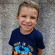 Bradley a rejoint le concours — aidez-le/la à gagner de superbes lots ! boy, casual, child, colorful, cute, daylight, face, graphic_tshirt, happy, outdoor, people, portrait, short_hair, smiling, standing, summer, text, tshirt, wall, young