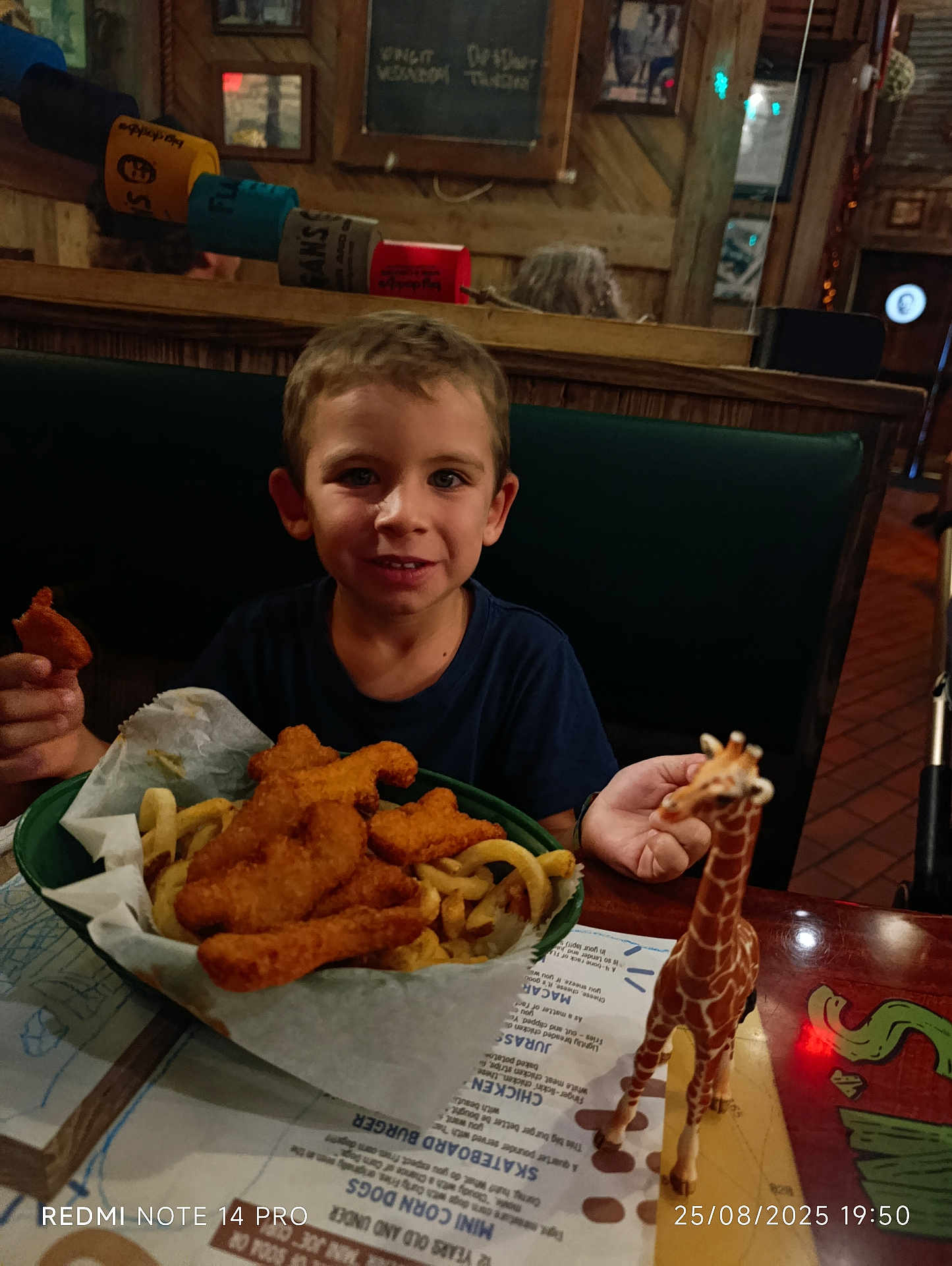 Bradley a rejoint le concours — aidez-le/la à gagner de superbes lots ! basket, boy, casual_clothing, chicken_nuggets, child, curly_fries, dining_booth, dinosaur_nuggets, food, fries, happy, indoor, meal, menu, paper_liner, restaurant, smile, table, toy_giraffe, wooden_wall