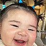 Naomi is registered to the contest to win money with this photo: baby, smiling, pigtails, hair_ties, face, indoor, video_call, person, child, happy, cute, infant, closeup, expression, home, apparel, young_child, digital_screen, technology, communication