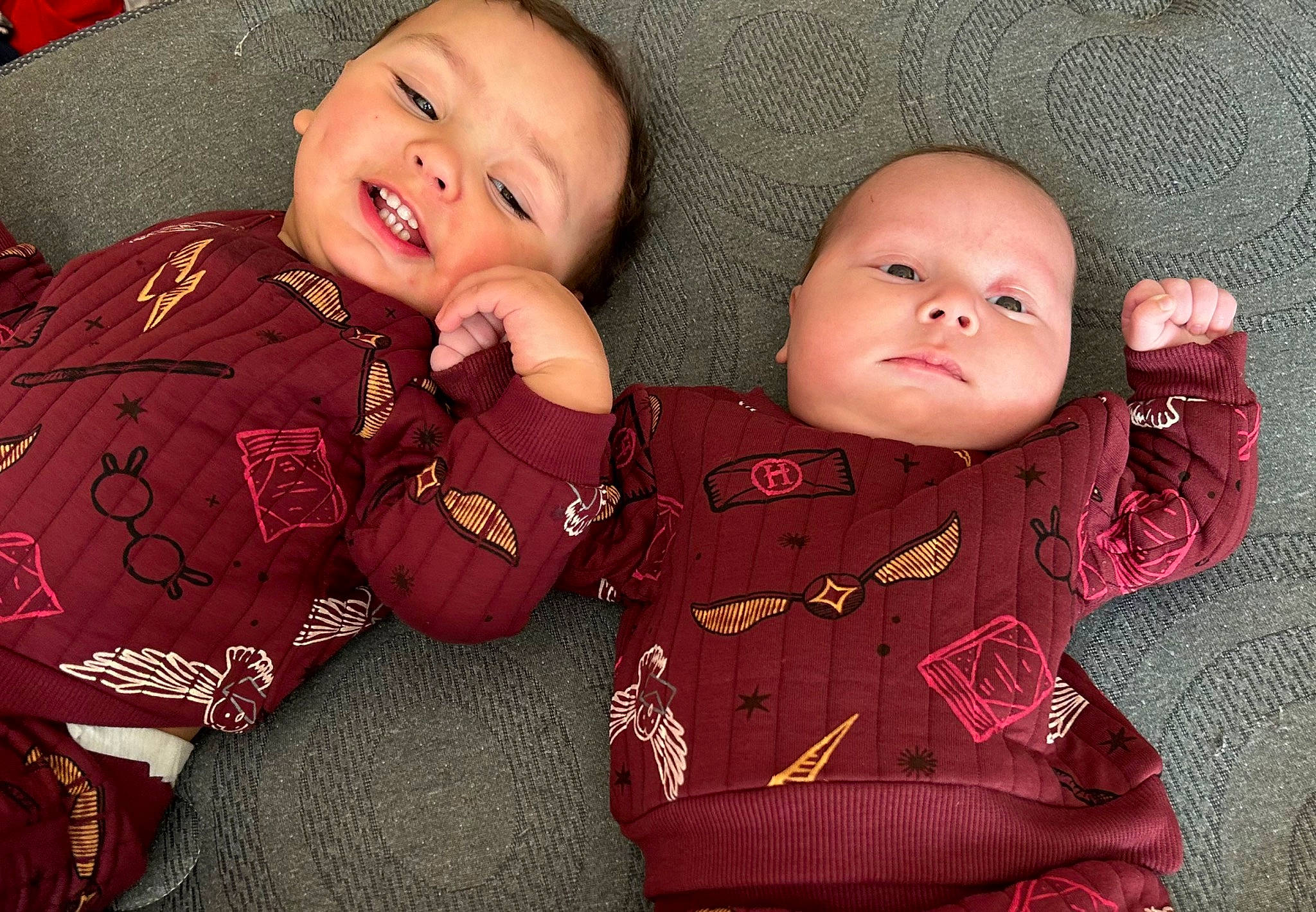 Justin is registered to the contest to win money with this photo: baby, baby_toddler_clothing, cheek, child, chin, comfort, eye, face, finger, happy, head, nose, outerwear, pattern, person, pink, skin, sleeve, smile, textile