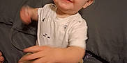 Eric is registered to the contest to win money with this photo: toddler, child, baby, person, indoor, bed, gray, shirt, shorts, smile, face, hand, foot, couch, clothing, happy, young, cute, light_skin, blond_hair