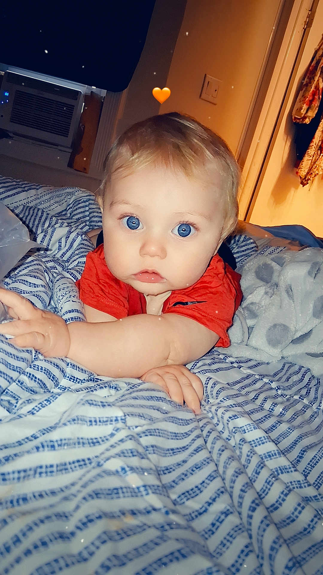 Eric joined the competition — help win amazing prizes! baby, blue_eyes, red_shirt, bed, blanket, striped, indoor, child, cute, face, expression, hand, arm, cozy, soft_lighting, heart_emoji, adorable, portrait, young_child, home