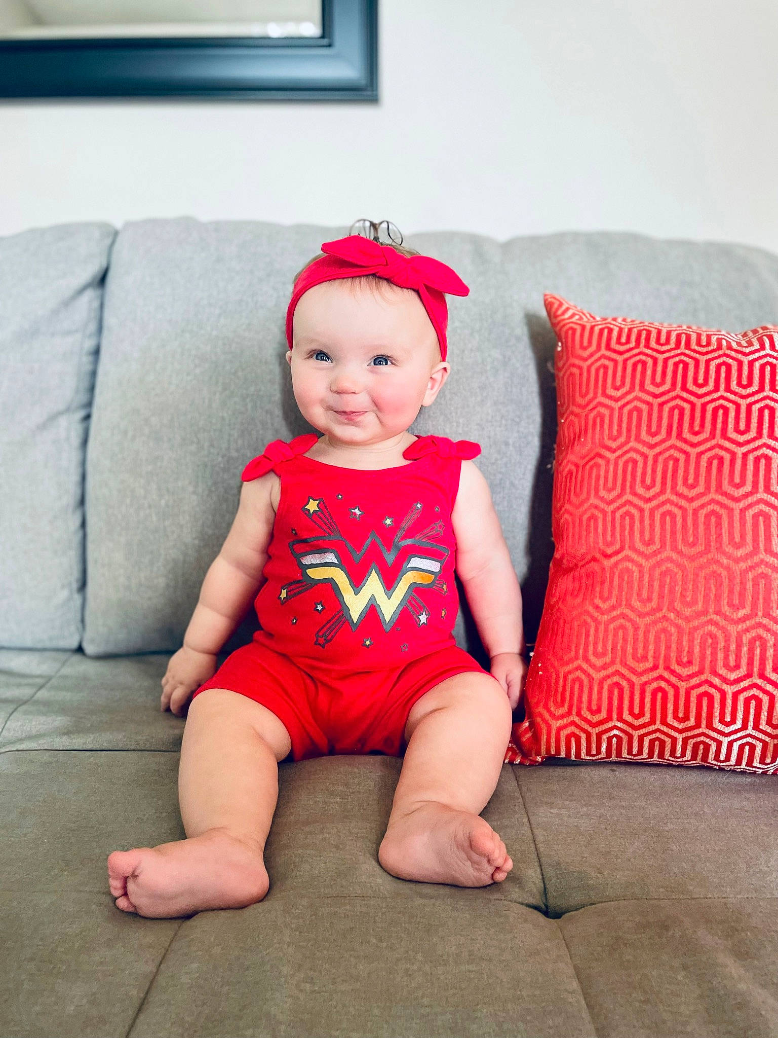 Nola is registered to the contest to win money with this photo: baby, baby_toddler_clothing, comfort, costume_hat, couch, dress, eye, face, happy, hat, head, human_body, human_leg, joy, knee, person, pink, sleeve, smile, t_shirt