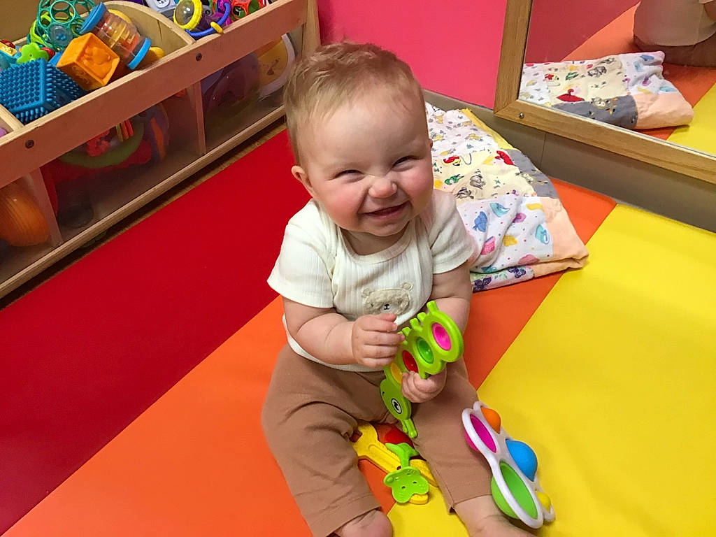Nola is registered to the contest to win money with this photo: baby, baby_playing_with_toys, baby_products, baby_toddler_clothing, baby_toys, child, comfort, floor, flooring, fun, happy, joy, leisure, person, play, room, sitting, skin, smile, toddler