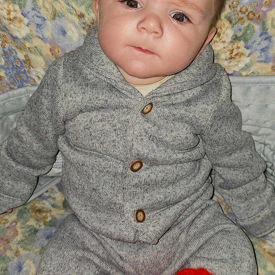 Janus is registered to the contest to win money with this photo: baby, bodypart, clothing, couch, face, finger, glove, hand, happy, head, hosiery, knitwear, pants, person, photography, portrait, smile, sock, sweater, toy
