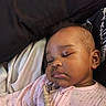 baby, sleeping, infant, pink_clothing, blanket, peaceful, face, child, cozy, resting, indoors, soft_lighting, closeup, person, cute, young, portrait, sleep, calm, relaxed
