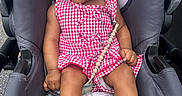 Leilani is registered to the contest to win money with this photo: accessory, baby, baby_clothes, car_seat, child, cute, footwear, happy, headband, infant, outdoor, person, portrait, red_checkered, sandal, seat, skin, smiling, summer_clothing, toddler