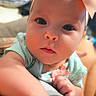 baby, infant, child, portrait, close_up, wide_eyes, bow, headband, mint_green_outfit, smiling, indoors, candid, face, eyes, hand, sitting, lap, home, soft_lighting, adorable