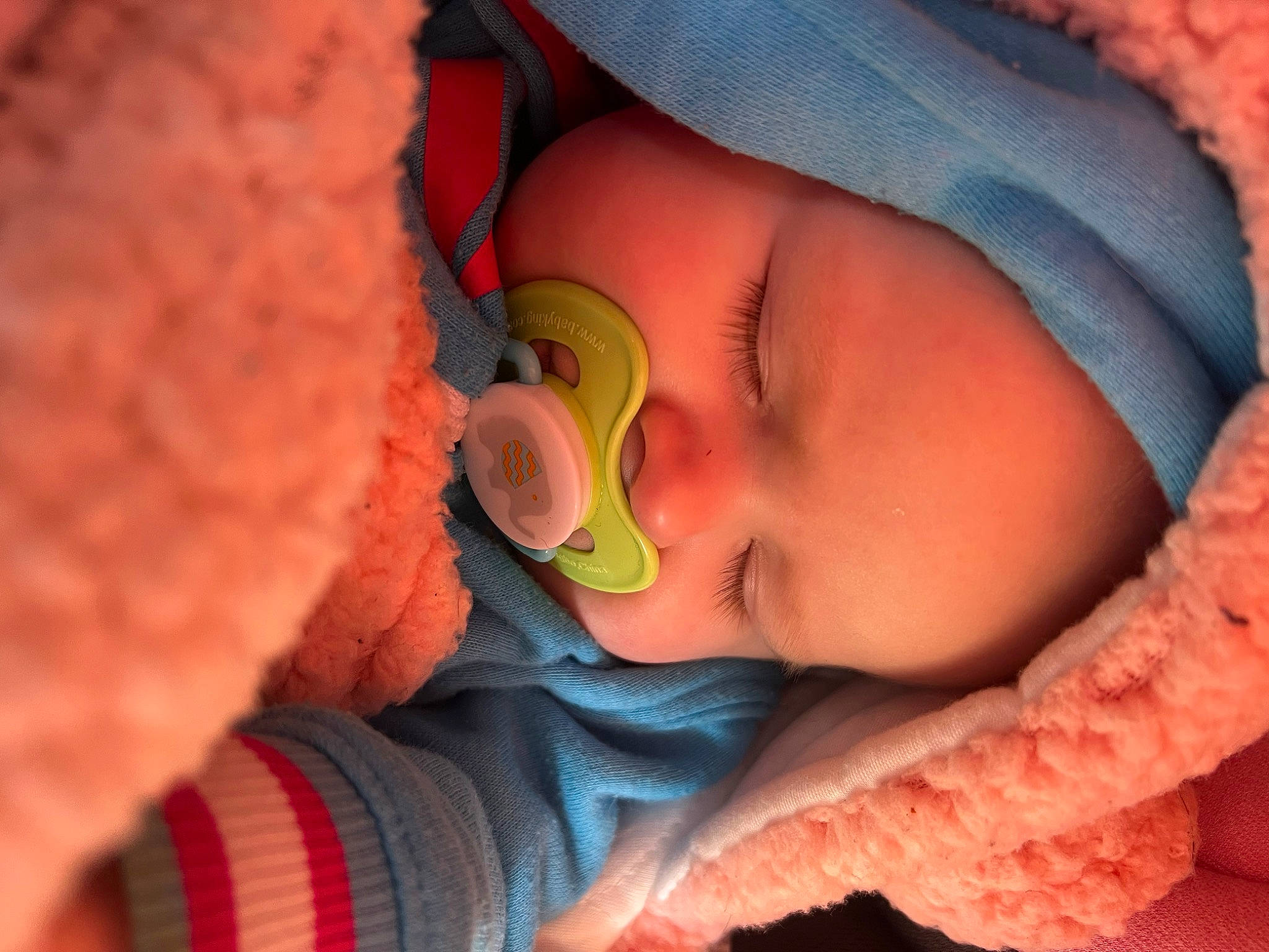 Josie is registered to the contest to win money with this photo: baby, cheek, chin, clothing, comfort, ear, eye, eyebrow, eyelash, face, forehead, human_body, lip, mouth, neck, nose, orange, person, pink, skin