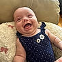 Ellie joined the competition — help win amazing prizes! baby, infant, smiling, laughing, polka_dot, navy_blue, flower, clothing, pillow, cushion, soft_fabric, arm, skin, indoor, happy, cute, person, child, resting, portrait