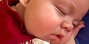 Ellie is registered to the contest to win money with this photo: baby, sleeping, closeup, face, cheek, arm, red_clothing, white_clothing, skin, peaceful, infant, child, portrait, cute, resting, indoors, soft_light, young, toddler, relaxing