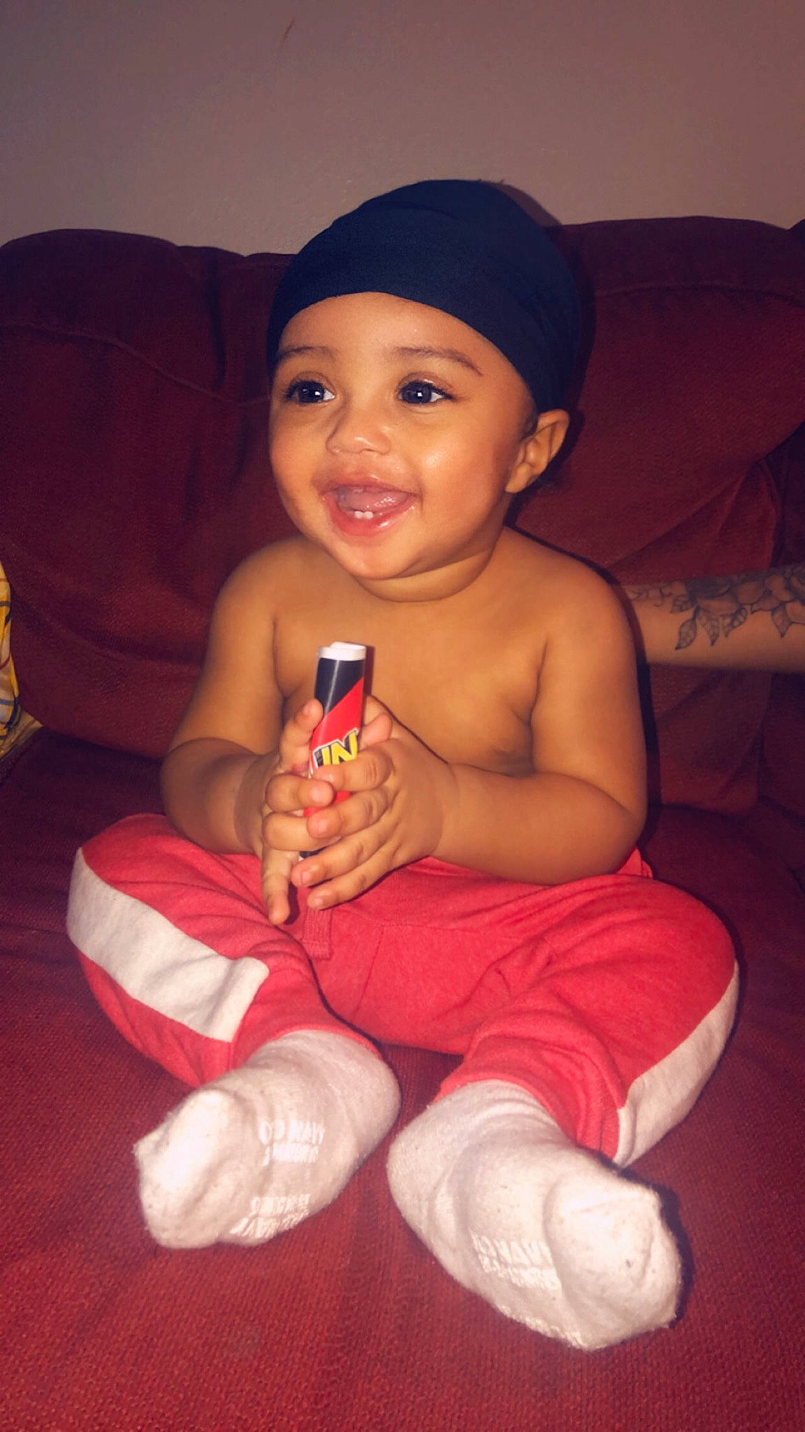 Davon is registered to the contest to win money with this photo: baby, cap, child, eye, finger, hat, head, headgear, joy, lip, person, sitting, skin, smile, thumb, toddler