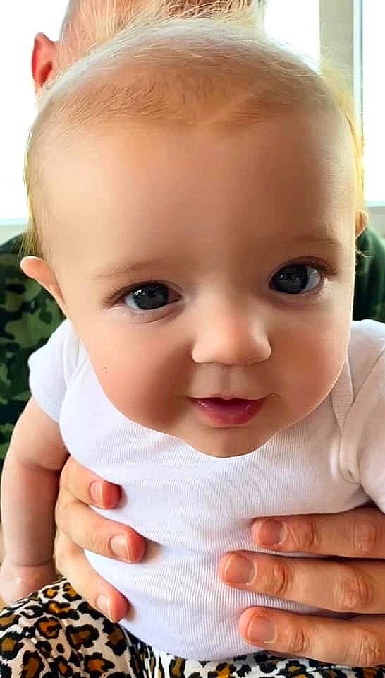 Arizona is registered to the contest to win money with this photo: baby, baby_toddler_clothing, cheek, chin, ear, eyebrow, eyelash, facial_expression, finger, gesture, hand, iris, lip, mouth, nose, person, pink, product, skin, sleeve