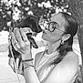 Suzie participe au concours pour gagner de l'argent avec cette photo : woman, dog, puppy, dachshund, black_and_white, glasses, tree, outdoor, leaves, kissing, holding, leash, bracelet, ring, earrings, sleeveless_shirt, portrait, close_up, nature, affection