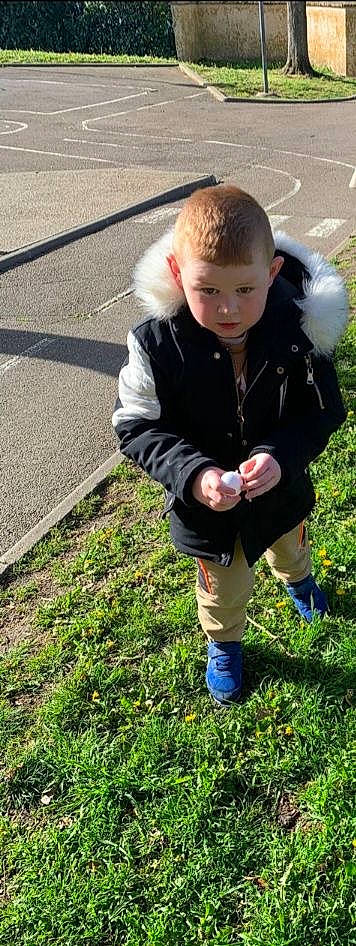 Raphaël participe au concours pour gagner de l'argent avec cette photo : asphalt, boot, child, denim, electric_blue, eye, face, fun, fur, grass, grassland, jacket, pattern, people_in_nature, person, plant, road_surface, sitting, sleeve, soil