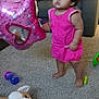 toddler, child, pink_dress, balloon, star_shaped_balloon, carpet, living_room, sofa, stuffed_animal, toy, barefoot, indoor, young_child, curly_hair, playtime, purple_sippy_cup, green_toy, couch, furniture, home