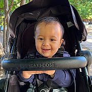 Avik joined the competition — help win amazing prizes! baby, child, stroller, smile, happy, outdoor, trees, sunlight, baby_clothing, seatbelt, black_stroller, park, nature, infant, portrait, cute, daylight, baby_face, baby_hands, casual