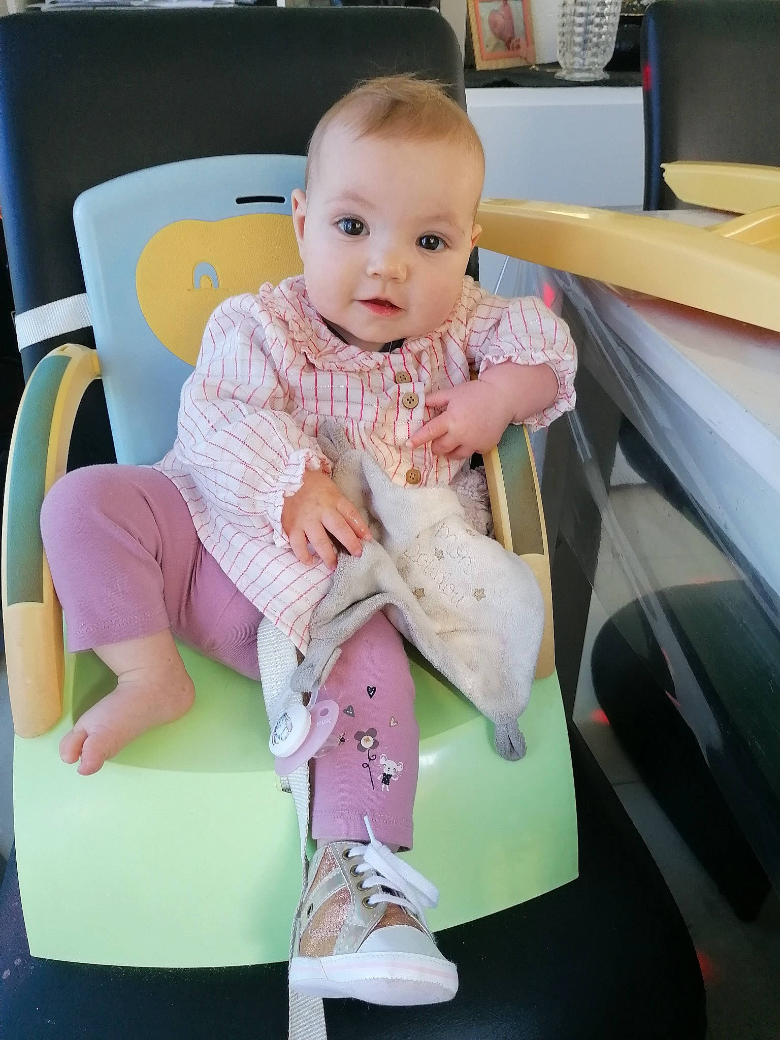 Loïcia participe au concours pour gagner de l'argent avec cette photo : baby, baby_products, baby_toddler_clothing, chair, child, comfort, flooring, happy, human_leg, knee, lap, linens, person, room, sitting, sleeve, smile, sock, t_shirt, thigh