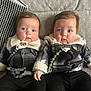 baby, twins, plaid_jacket, black_pants, boots, blue_eyes, rosy_cheeks, couch, indoor, cute, child, infant, portrait, matching_outfits, warm_clothing, sitting, closeup, person, adorable, toddler