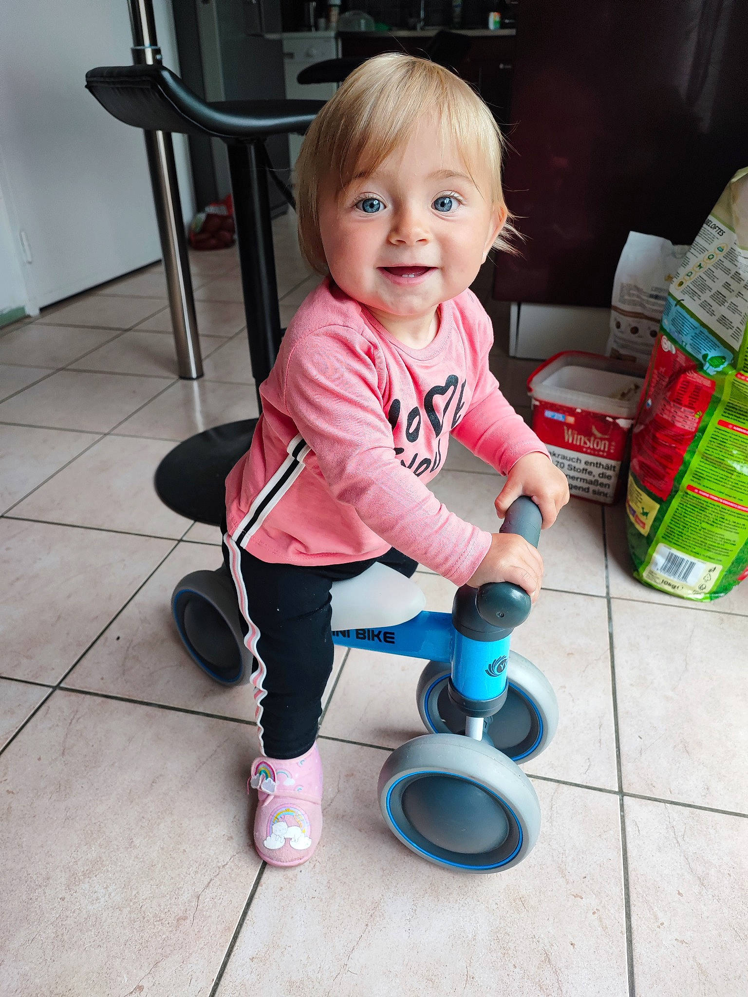 Lyana a rejoint le concours — aidez-le/la à gagner de superbes lots ! baby, baby_products, baby_toddler_clothing, child, floor, flooring, fun, hair, happy, household_supply, joy, person, plastic_bottle, play, product, sitting, smile, tire, toddler, toy