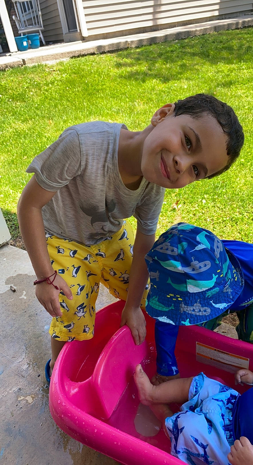 Daniel is registered to the contest to win money with this photo: child, event, fun, games, grass, happy, joy, leisure, pattern, people_in_nature, person, plant, plastic, play, recreation, sandal, shorts, sitting, smile, soil