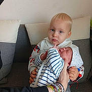 Thiago a rejoint le concours — aidez-le/la à gagner de superbes lots ! baby, bracelets, child, close_up, comfort, couch, crying, cushion, family, hand, hat, holding, indoor, living_room, newborn, person, serious_expression, soft_furniture, striped_clothing, toddler