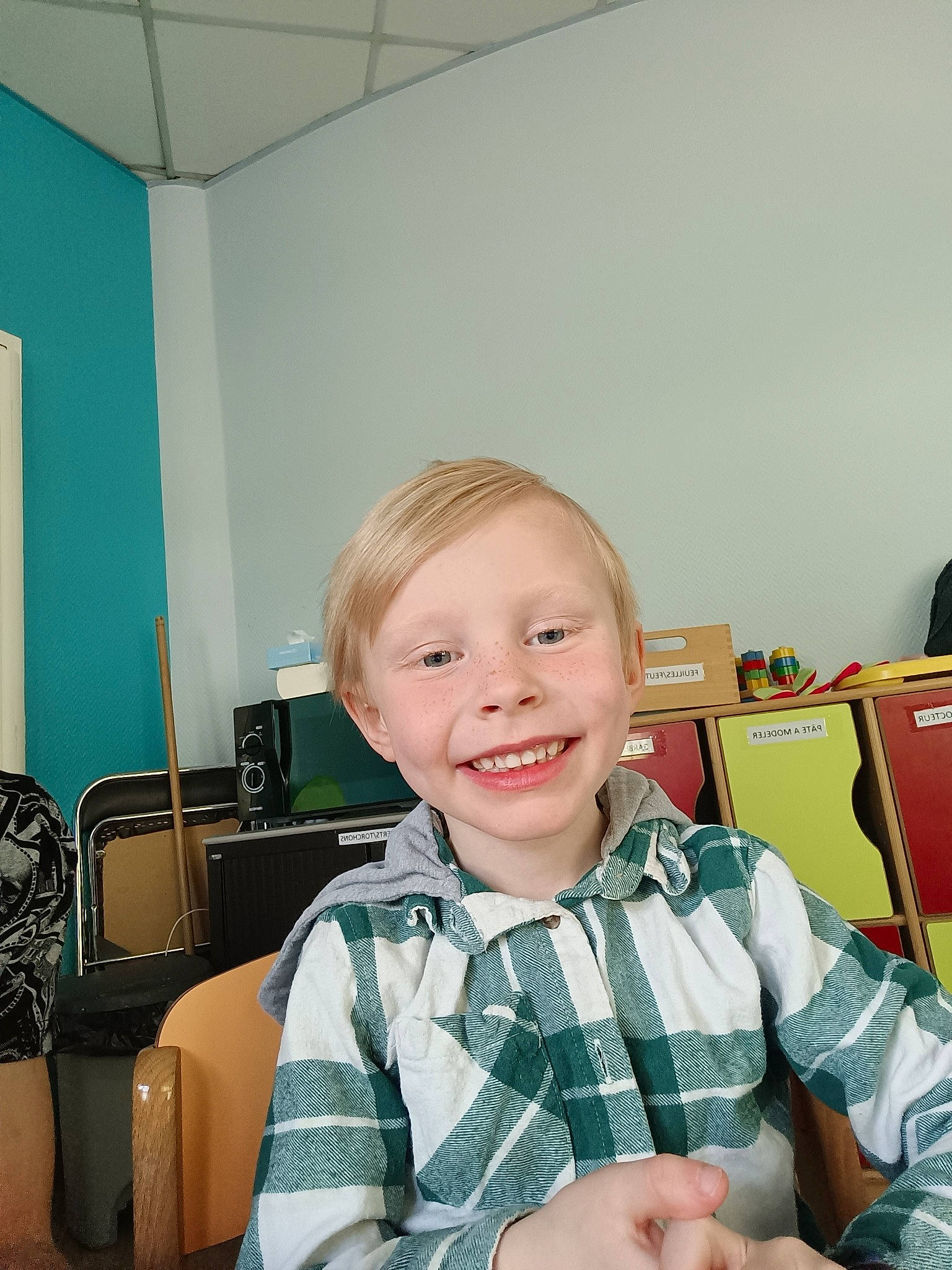 Inenzo participe au concours pour gagner de l'argent avec cette photo : ceiling, chair, child, desk, drawer, flooring, fun, happy, joy, lap, learning, living_room, pattern, person, plaid, play, room, sitting, smile, t_shirt