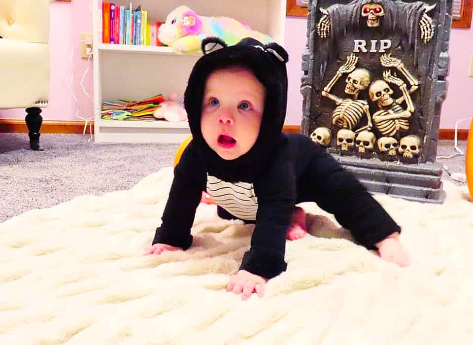 Evelynn is registered to the contest to win money with this photo: baby, black_hair, child, flooring, head, headwear, nose, outerwear, pajamas, person, sleeve, smile, surprise, toddler
