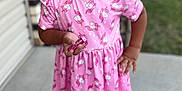 Zai'Lynn joined the competition — help win amazing prizes! background_blur, casual_clothing, child, concrete, crocs, curly_hair, daylight, earrings, footwear, girl, happy, holding_candy, house, outdoor, pink_dress, porch, portrait, smiling, standing, unicorn_pattern