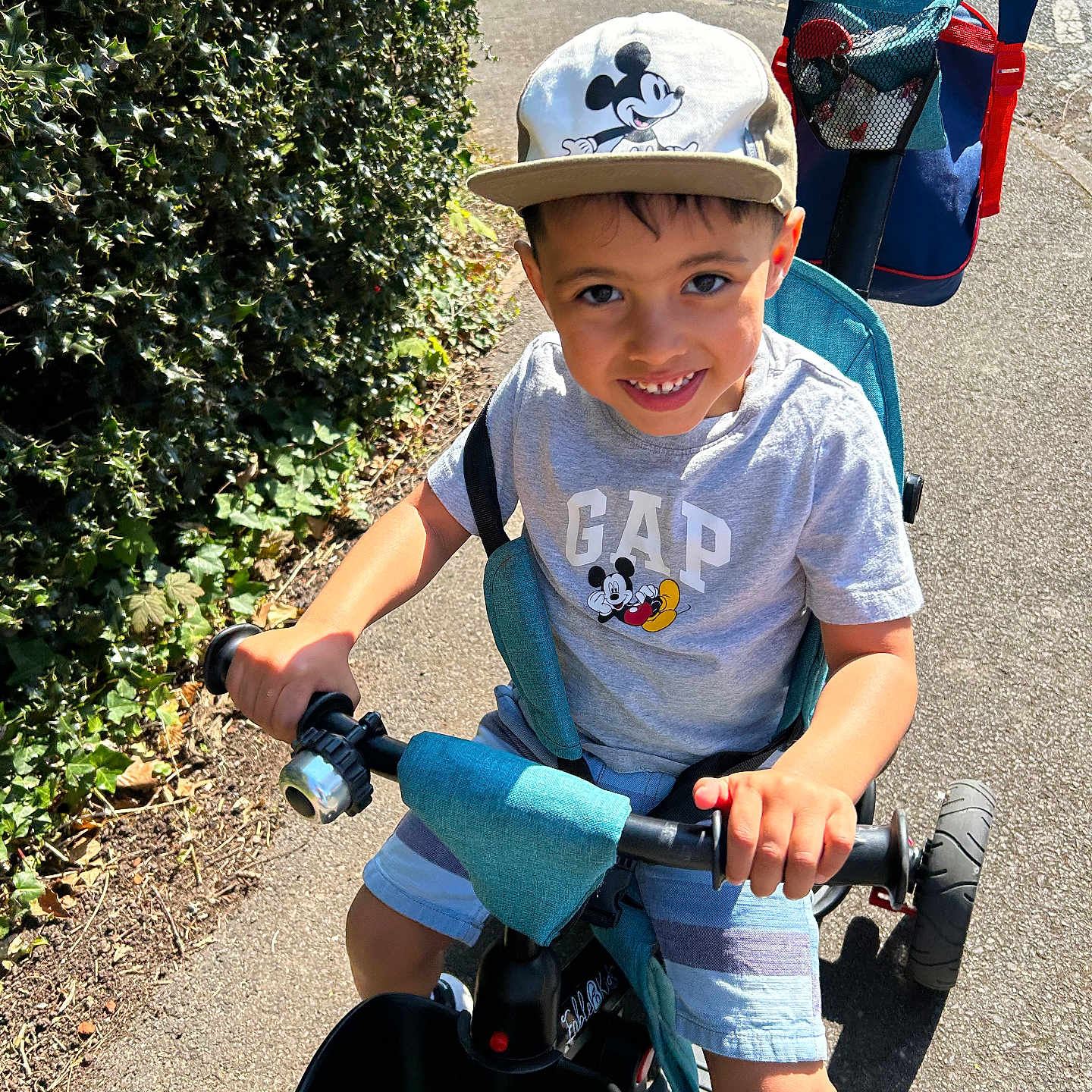 Lucas joined the competition — help win amazing prizes! boy, cap, child, daytime, footwear, fun, gap, greenery, handlebars, happy, mickey_mouse, outdoor, pavement, play, shorts, smiling, summer, sunny, tricycle, tshirt